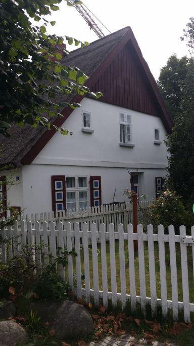 Typisches einladendes Haus mit Garten und weißem Zaun.