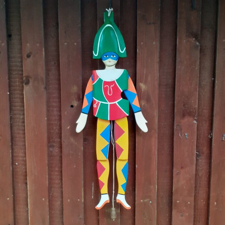 Bunter Holzkunst-Hampelmann an einer Wand.