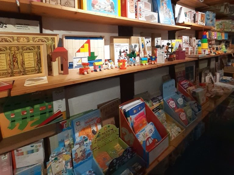 Regal mit Spielzeug und Kinderbüchern in einer gemütlichen Atmosphäre.